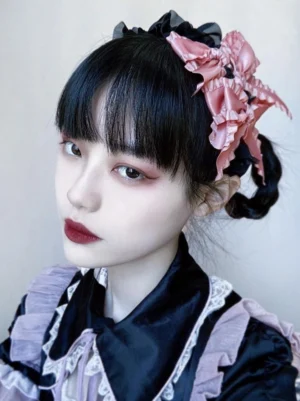 Black ruffled gothic lolita hair accessory with pink satin bows frontal portrait view on model wearing maid-style lolita dress