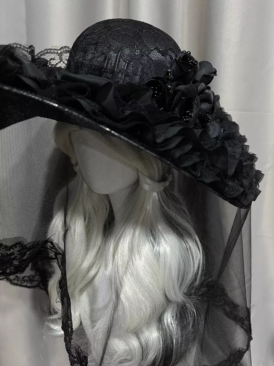 Gothic lolita hat with black flower embellishments and textured crown, right front three-quarter angle with mannequin