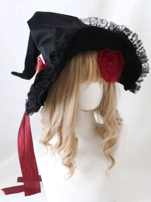 Black Gothic Lolita headdress witch hat with red fabric rose decoration and wine red satin ribbon - front three-quarter view on blonde curly wig