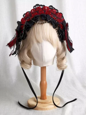 Front central view of Gothic Lolita two-tone headdress featuring layered red and black lace ruffles, decorative bead chain accents, and long hanging ribbon straps on mannequin