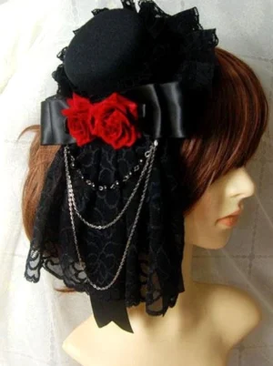 Side profile view of Gothic Lolita headdress showing draped black patterned lace veil, multi-strand metal chains, and miniature top hat base structure