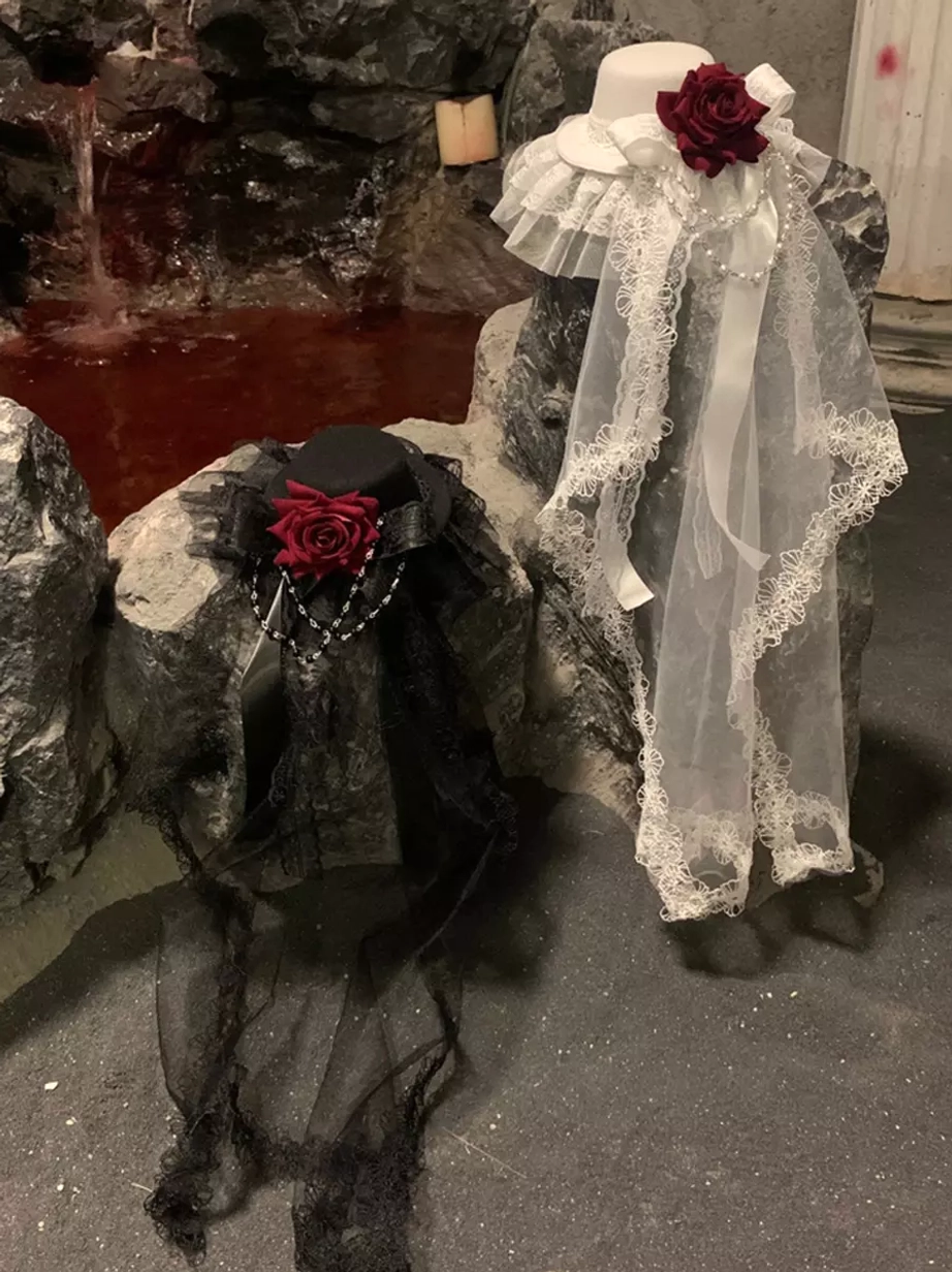 Pair of Gothic Lolita headdress styles in black and white with red rose details, static front product shot with rocky water pool background