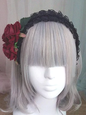 Gothic Lolita headdress front view showing full arrangement of wine-red roses with green foliage and buds on black lace band, worn on mannequin with silver bangs wig
