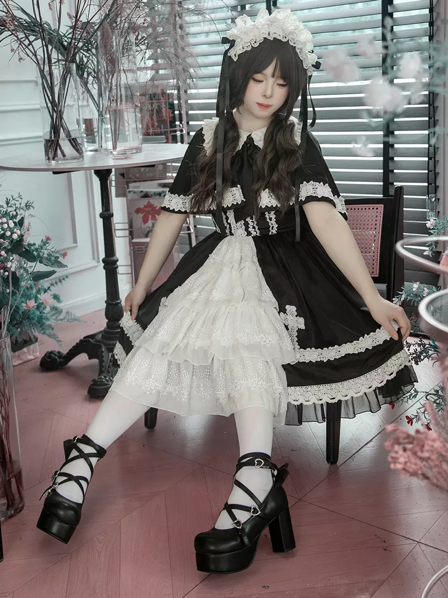 Gothic lolita JSK dress back view detail showing full cross embroidery pattern, lace hem trim, and structured silhouette from rear perspective