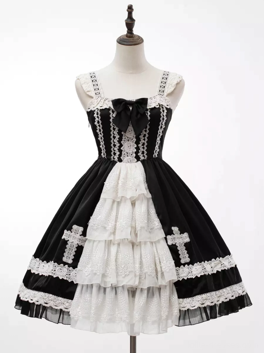 Flat lay product shot of gothic lolita JSK dress displaying full silhouette, lace trims, ruffled layers, cross embroidery patterns, and overall dress construction
