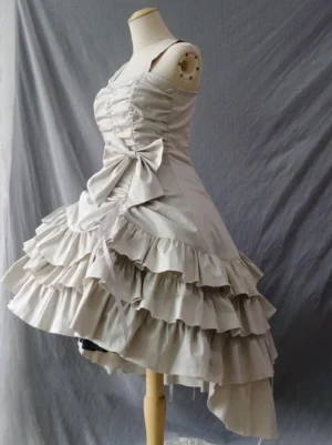 Gothic lolita jumper skirt left side view displaying ecru white color asymmetric layered ruffles waist bow and ruched bodice detail