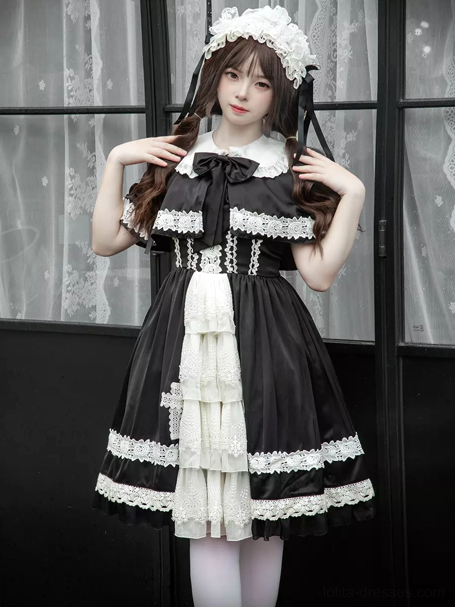 Upper body standing view of gothic lolita dress featuring Peter Pan collar, cross-shaped lace waist trim, decorative neck bow, and multi-layered white ruffled front panel