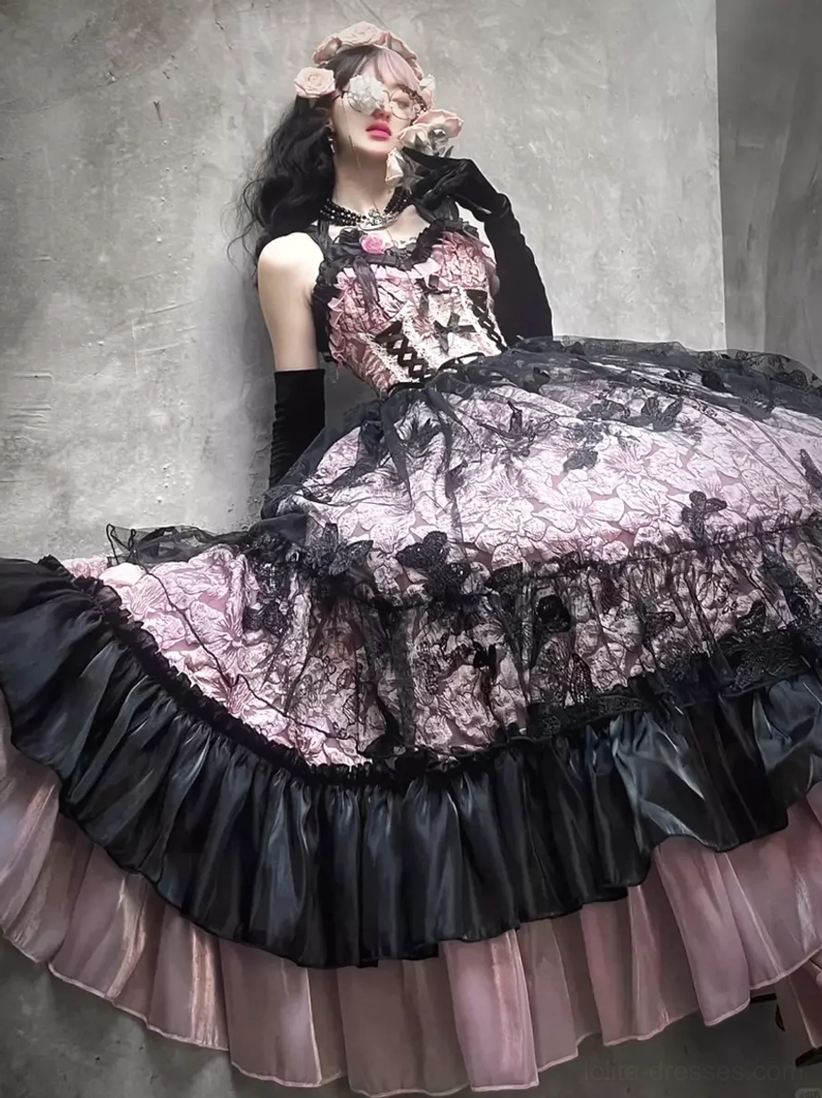 Low-angle model shot of pink gothic Lolita JSK gown showcasing corset waist design and voluminous skirt with floral headpiece
