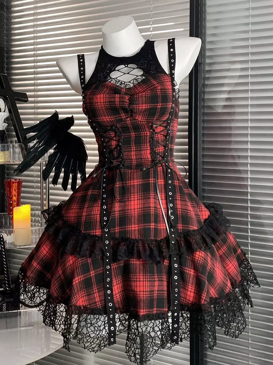 Red and black plaid gothic lolita JSK dress front three-quarter view with halter cutout neck and lace-up front panel adorned with metal rivets, worn with ruffled lace hem detail