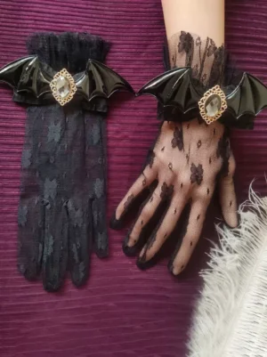 Gothic lolita black floral lace oversleeves with black bat PU trim and gold-rimmed rhinestones, ruffled lace cuff detail, worn styling shot with white feather accessories on dark purple background