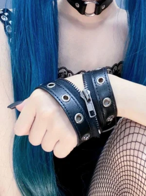 Punk leather wrist cuffs side view showing double-strap construction and metal grommet detailing worn with fishnet stockings and black goth dress on model
