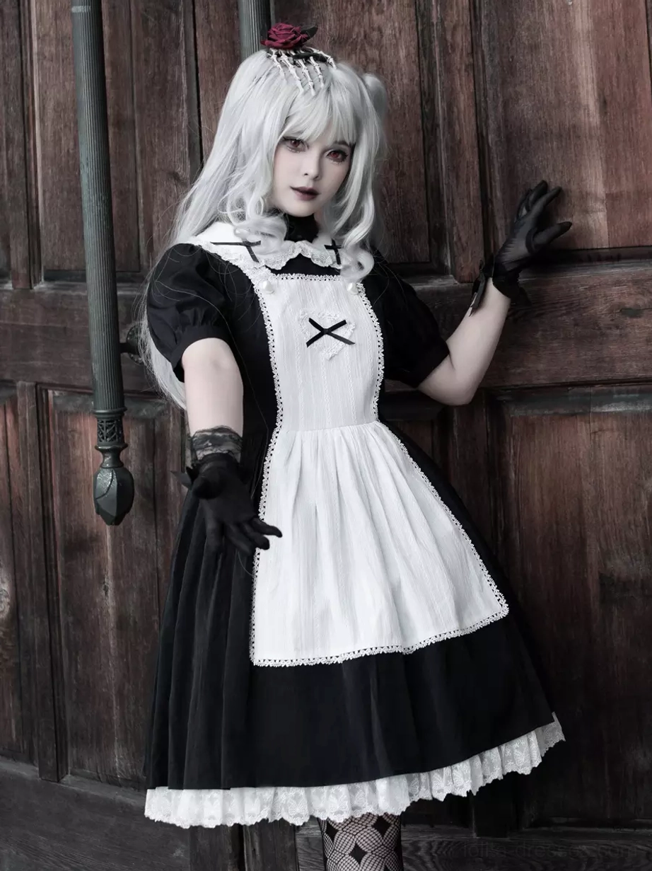 Gothic Lolita maid dress medium distance front view, model leaning one hand on vintage wooden door, cross apron decoration visible, lace trim details