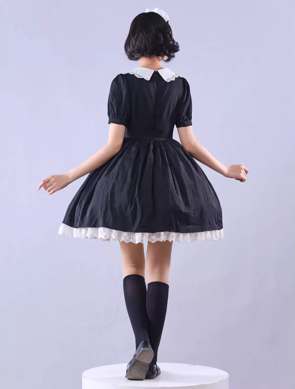 Gothic Lolita maid dress back view showing cross apron design, lace ruffle skirt hem from rear, overall silhouette proportion and volume