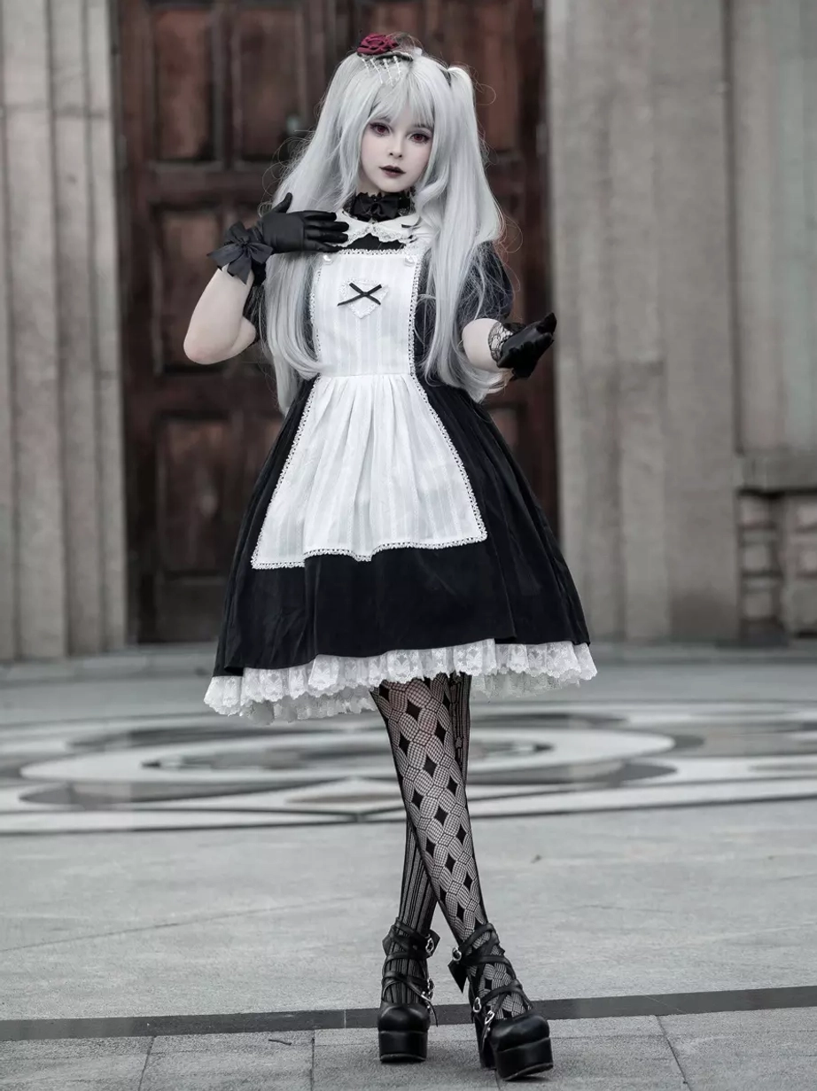 Full body front Gothic Lolita maid dress coordinate, model with hands posed near cheeks, diamond fishnet stockings, outdoor stone square venue