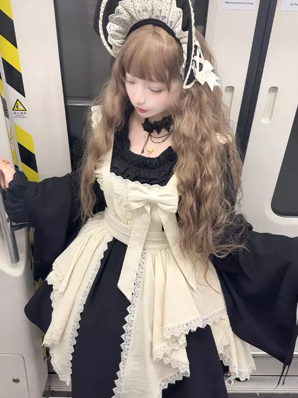 Close-up front detail of Gothic Lolita maid dress featuring irregular hemline lace apron, oversized cream front bow, and bell sleeve cuffs