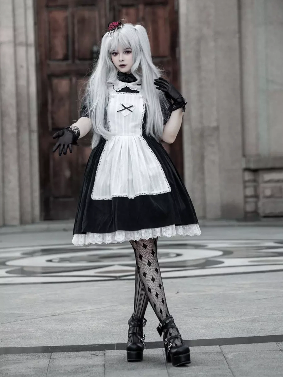 Close-up front view of Gothic Lolita maid dress showing ruffled short sleeves, puff sleeve details, lace embellishments, model with raised hands near chest