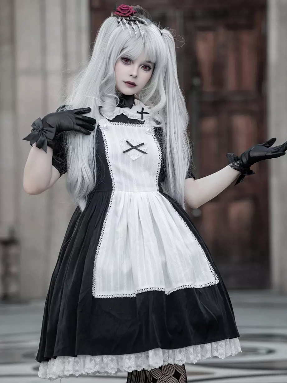 Gothic Lolita maid dress front view with rose hair accessory, formal black gloves, lace-trimmed apron edge details, vintage wooden door background