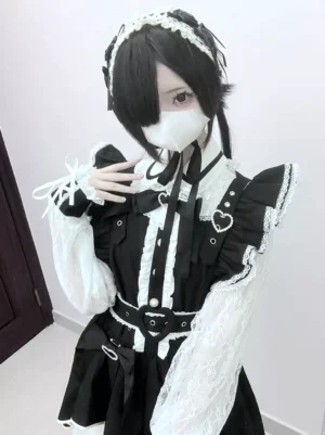 Gothic maid-style Lolita dress close-up front view with black-white color, lace trims, heart-shaped decorations, masked female model indoor doorway