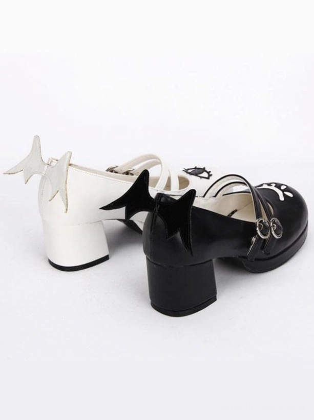 Side flat lay view of Gothic Lolita Mary Jane shoes showing evil wing heel accents dual buckle straps and face prints on shoe upper patchwork design