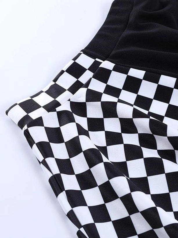 Close-up detail of black-white checkerboard fabric texture on gothic lolita mini skirt, showing woven pattern quality and folded fabric construction