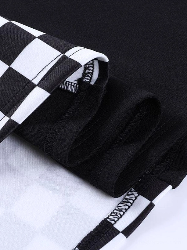 Close-up detail of gothic lolita mini skirt joint seam where checkerboard fabric meets solid black fabric with visible hem stitching