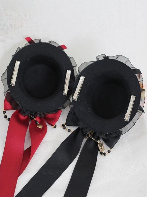 Pair of gothic lolita mini top hat hairclips back flat view showing visible hairclip fasteners and matching bow tassels in detail