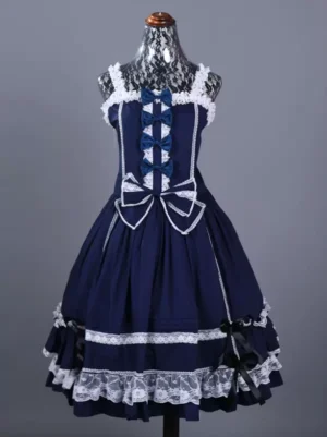 Navy gothic lolita jumpskirt front view showing color block design with white lace trim, decorative front bows, large waist bow, and layered ruffled skirt on dress form