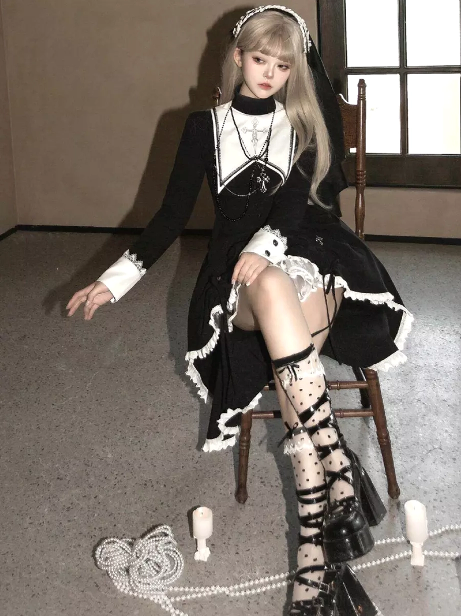 Three-quarter seated view of gothic lolita high-low dress showing ruffled hem details and proportions, styled with white polka dot lace socks and platform lace-up heels on wooden chair