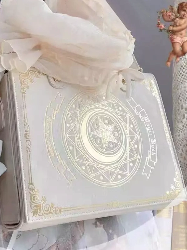 Off-white Gothic Lolita book bag with mini angel ornament decoration and light golden moon star magical pattern on smooth matte PU leather