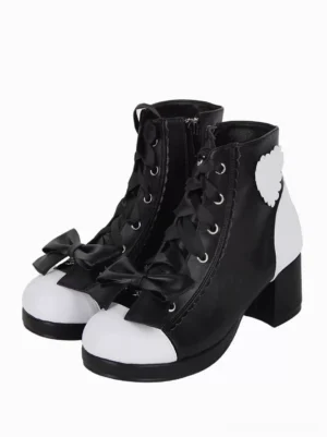 Gothic lolita open toe ankle boots black and white color block front three-quarter view with decorative bow scalloped heart patch metal eyelets