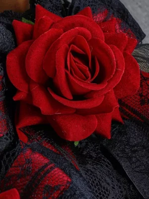 Close-up detail of gothic lolita oversleeves showing intricate black mesh lace and flocked red velvet rose attached to gothic dress