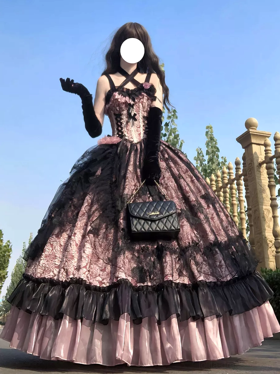 Model side-front view of pink gothic Lolita ball gown showing multi-layered ruffled tulle skirt with black gloves and chain bag