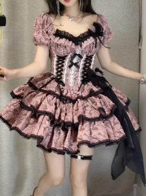 Pink and black floral Gothic Lolita dress with lace-up corset bodice, tiered ruffled skirt, and puff sleeves on model wearing head bow and ankle strap heels, front view