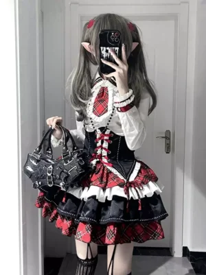 Gothic Lolita plaid coordinate set with red and black tartan pattern, lace-up corset waist, and ruffled short sleeve blouse shown on model with twin-tail hairstyle and elf ear accessories