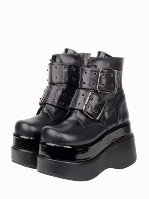 Pair of black gothic lolita platform ankle boots with dual grommet buckles front three-quarter view on white background showing glossy patent finish and round toe design