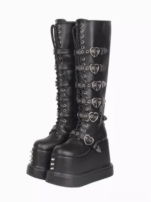 Gothic lolita platform boots black PU leather front three-quarter view showing heart-shaped metal buckles and thick wedge platform sole with decorative studs
