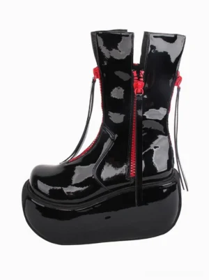 Black patent leather Gothic Lolita platform boot left side profile view showing glossy finish red zipper accent leather zipper pull and thick platform sole