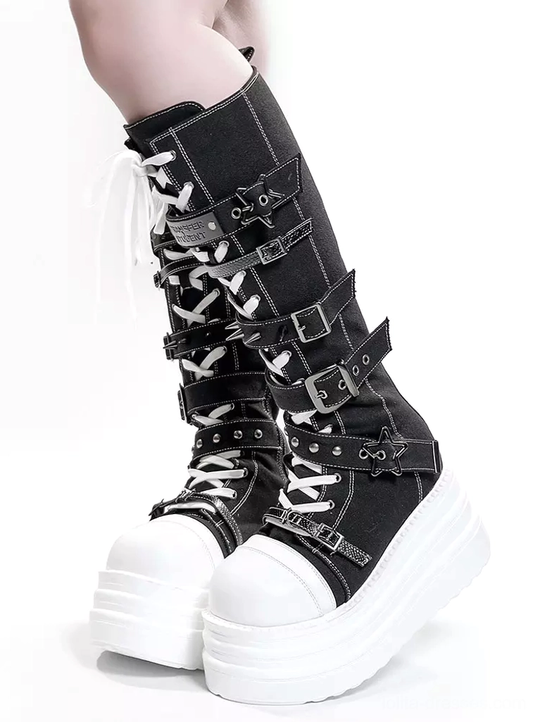 Side view of black and white lolita punk platform boots featuring adjustable metal straps, chunky white platform sole, and silver star buckles on plain white background