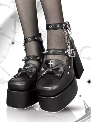 Gothic lolita platform boots with metal chains and bows worn on feet close-up front view with black sheer stockings