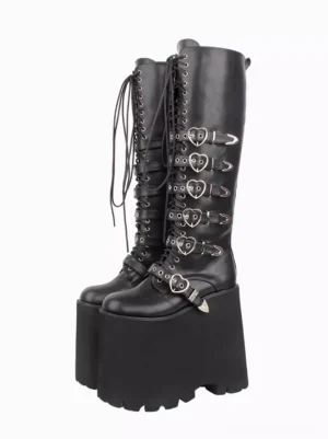 Black Gothic Lolita platform knee-high boots with heart-shaped metal buckles and lace-up front closure, side view showcasing thick wedge sole and rounded toe design on white background