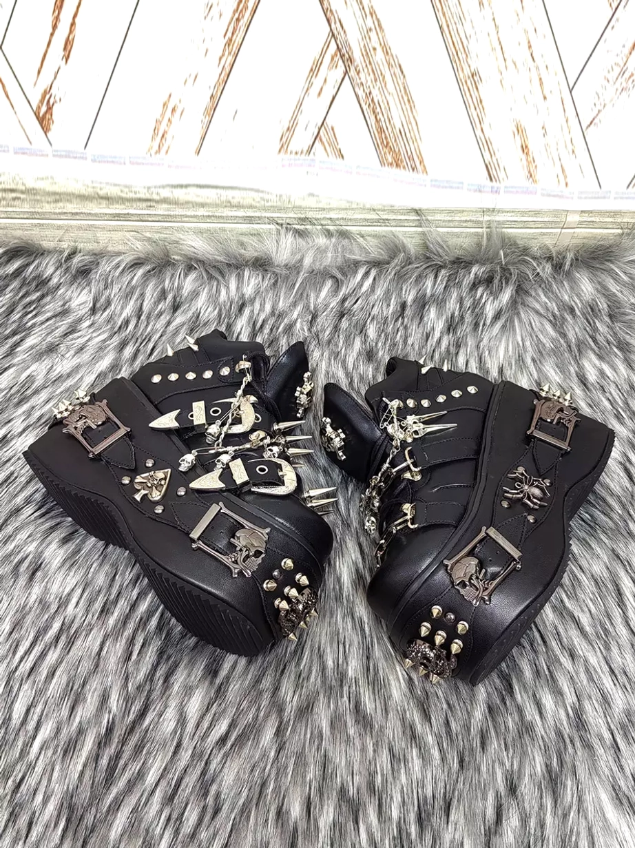 Overhead flat lay view of gothic punk platform boots displaying sole and underfoot metal hardware details on furry rug background showing thick platform thickness