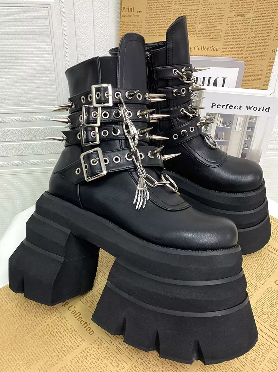Gothic Lolita platform boots pair right three-quarter view ornate silver metal chains spikes massive layered platform soles round toe newspaper backdrop