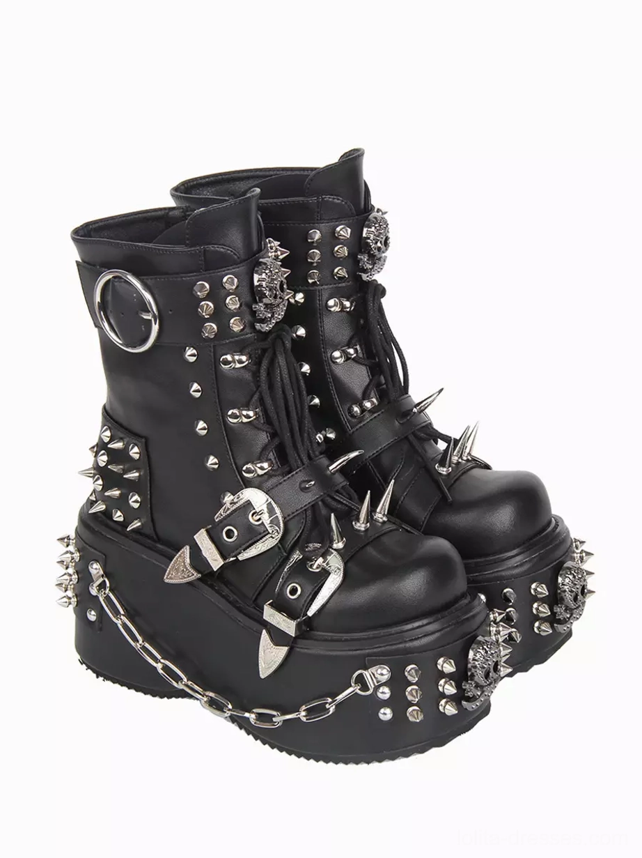 Pair of Gothic Lolita platform boots right front three-quarter angle displaying high thick wedge sole, round buckles, metal spikes, studs throughout, intricate chain embellishments, and lace-up construction