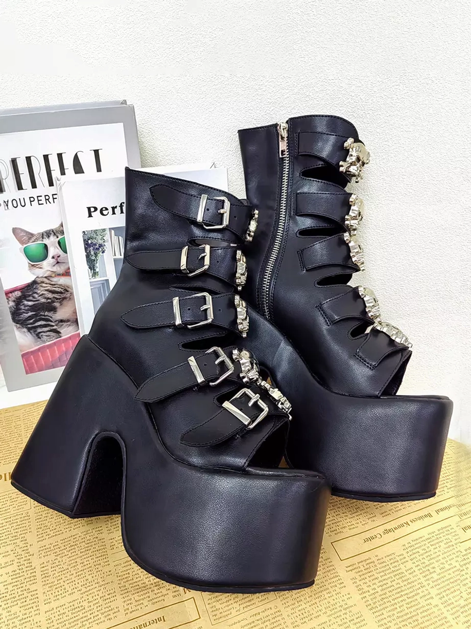 Pair of Gothic Lolita platform boots back view on vintage newspaper backdrop with fashion magazines black PU leather silver skull buckles