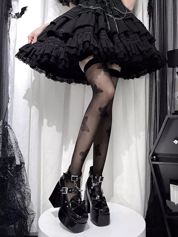 Side lower leg view model wearing gothic lolita boots with shiny patent leather black skirt butterfly stockings metal chain decor