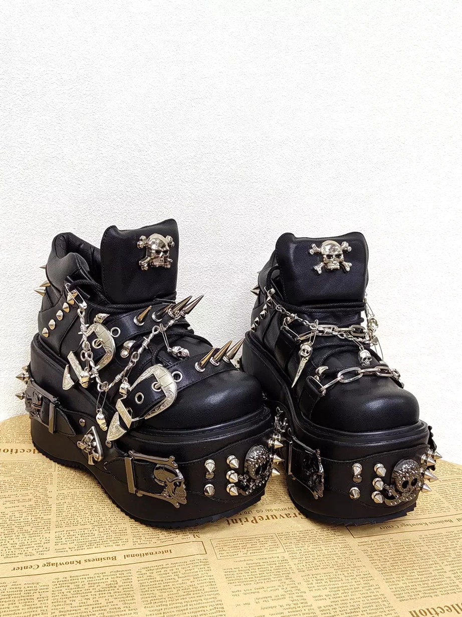 Side three-quarter view of gothic punk platform lolita boots featuring side-mounted metal buckles skull and spike decoration on black leather with wedge heel