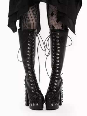Gothic lolita platform boots front view with silver grommets and lace-up design, model wearing diamond fishnet stockings and black skirt, chunky block heel and mid-calf shaft