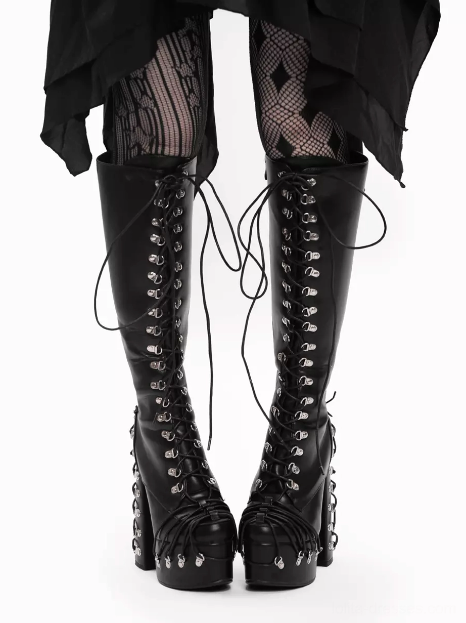 Gothic lolita platform boots front view with silver grommets and lace-up design, model wearing diamond fishnet stockings and black skirt, chunky block heel and mid-calf shaft