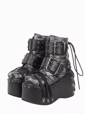 Gothic Lolita platform ankle boots front three-quarter view featuring skull print polyurethane upper with metal grommets buckles and studded wedge platform sole on white background