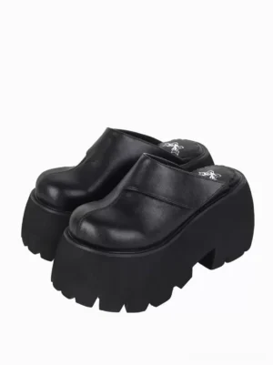 Gothic lolita platform mule sandals front three-quarter view showcasing solid black PU leather upper with rivet embellishments and serrated thick platform sole